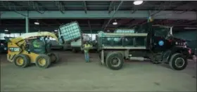  ?? ERIC BONZAR — THE MORNING JOURNAL ?? Workers load a brine sprayer onto a Lorain snow plow truck at the city’s 114 E. 35th St. garage, Nov. 21.