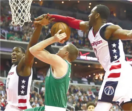  ?? AP FOTO ?? NOT TONIGHT. The Washington Wizards center Ian Mahinmi (left) and guard John Wall stop Boston Celtics forward Jonas Jerebko (center). The Wizards arrested Boston’s win streak to close in on the series, 2-1.