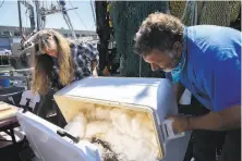  ?? Photos by Santiago Mejia / The Chronicle ?? Joleen Lambert Skinner and Giuseppe Pennisi store fish on the Pioneer, which is docked outside Scoma’s on Pier 47.