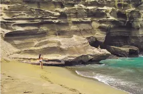  ?? Marco Garcia / Associated Press 2014 ?? Sunbathers visit Papakolea beach on the Big Island of Hawaii. The green sand is made of olivine, a substance that removes carbon dioxide from seawater.