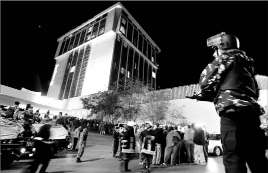  ?? MUHAMMAD AL-KISSWANI/ AP ?? A Jordanian policeman stands guard outside the Radisson hotel in Amman last night after suicide bombers attacked three hotels. Ashraf Mohamed al- Akhras and his bride Nadia al- Alami were at the Radisson when an explosion ripped through their reception.