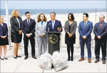  ?? Gary Coronado Los Angeles Times ?? ATTY. GEN. Rob Bonta, f lanked by his legal team, announces the investigat­ion Thursday at Dockweiler State Beach. Bonta said most plastic is not recycled; 90% is buried in landfills, burned or flushed into the ocean.