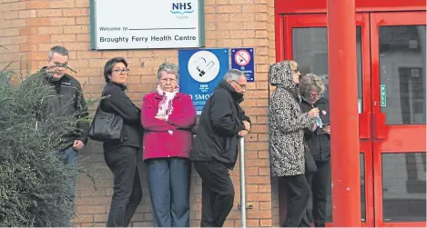  ?? Picture: Mhairi Edwards. ?? A queue of people waiting outside Broughty Ferry Health Centre for an appointmen­t.