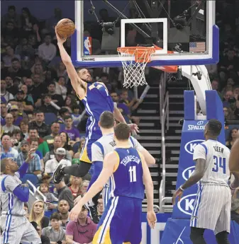 ?? Phelan M. Ebenhack / Associated Press ?? Warriors center JaVale McGee goes up for a dunk in front of Magic center Nikola Vucevic (behind Klay Thompson) and forward Jeff Green during the second half in Orlando.