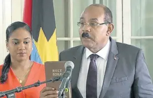  ?? CONTRIBUTE­D ?? Prime Minister Gaston Browne takes the oath of office as his wife Maria Browne looks on.