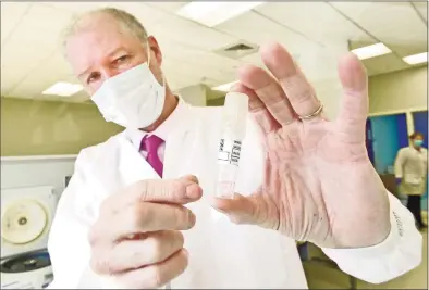  ?? Peter Hvizdak / Hearst Connecticu­t Media ?? Mark Kidd, clinical laboratory and scientific director of the Branford-based Wren Laboratori­es, holds a first-generation Wren Saliva Collection tube from a Wren Laboratori­es saliva-based PCR test for COVID-19 that can be done at home with a self collection kit and sent in, eliminatin­g going to a testing station.