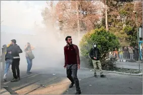  ?? AP PHOTO ?? In this photo taken by an individual not employed by the Associated Press and obtained by the AP outside Iran, university students attend a protest inside Tehran University while a smoke grenade is thrown by anti-riot Iranian police Saturday in Tehran.