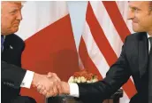  ?? EVAN VUCCI/ASSOCIATED PRESS ?? President Donald Trump shakes hands with French President Emmanuel Macron during a meeting at the U.S. Embassy in Brussels.