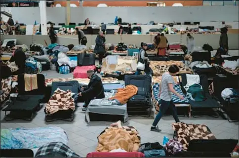  ?? AP ?? Ukrainian refugees rest at a refugee center in Nadarzyn, near Warsaw, Poland. An estimated 8 million Ukrainians have fled Russian troops, with European countries struggling to cope with the displaced.