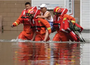  ?? PICTURE: EPA ?? EXTREME SWING: Rescuers carry a man in a flooded area in Shenyang, China. The northern hemisphere, where most of the largest countries by GDP are found, emits far more greenhouse gas than the southern hemisphere does.