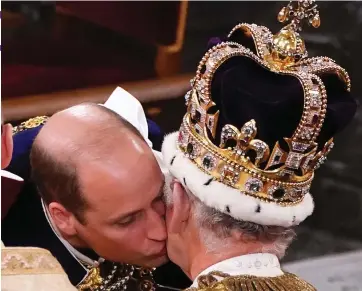  ?? ?? Heavy is the head: Prince William kisses his father at his long-awaited Coronation