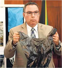  ?? RICARDO MAKYN ?? Minister without portfolio in the Ministry of Economic Growth and Job Creation, Daryl Vaz, holds a foam plastic bag during yesterday’s press conference.