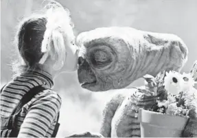  ?? UNIVERSAL STUDIOS ?? Gertie (Drew Barrymore) kisses her out-of-this-world friend in the ’80s tear-jerker classic “E.T. the Extra-Terrestria­l.”