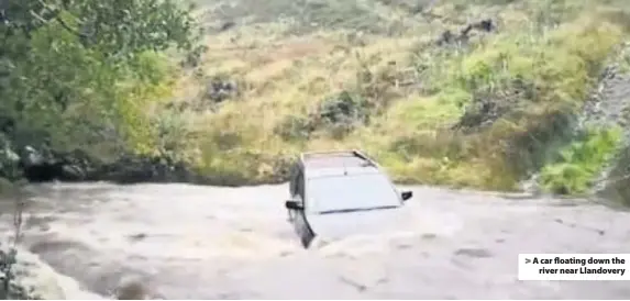  ??  ?? &gt; A car floating down the river near Llandovery