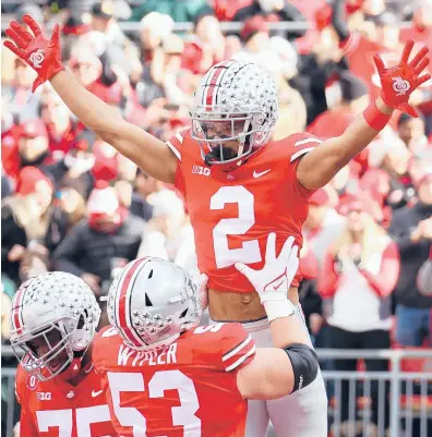  ?? GREGORY SHAMUS/GETTY ?? Ohio State’s Chris Olave (2) celebrates a touchdown catch with Luke Wypler (53) on Saturday at Ohio Stadium.