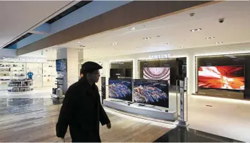  ?? — Bloomberg ?? Driving growth: A man walks past Samsung television sets displayed at the company’s D’light flagship store in Seoul. The firm has unveiled plans to invest Us$151bil (Rm663bil) through 2030 to delve deeper into advanced products.