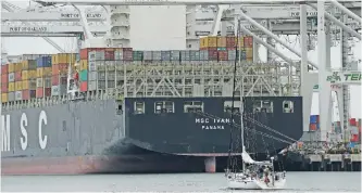  ??  ?? OAKLAND: A sailboat makes its way past the container ship MSC Ivana as she is unloaded at the Port of Oakland in Oakland, California. The Commerce Department reported on the US trade gap for October yesterday. — AP
