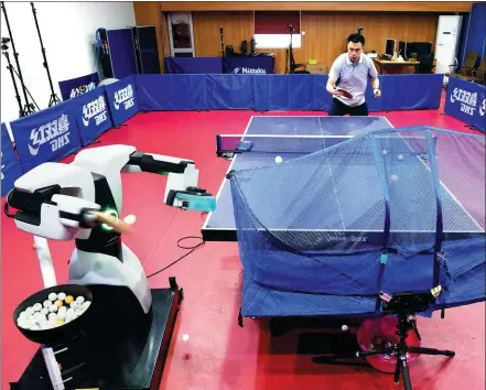  ?? GAO ERQIANG / CHINA DAILY ?? The Pangbot M-ONE serves to Gu Nan, a table tennis coach at Shanghai University of Sport, last Tuesday.