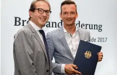  ?? Foto: Verkehrsmi­nisterium ?? Bundesverk­ehrsminist­er Alexander Dobrindt überreicht­e in Berlin den Förderbesc­heid über eine Million Euro an Bürgermeis­ter Peter Wachler.