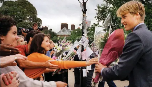  ??  ?? Forcing a smile: William receives flowers at Kensington Palace as he inspects tributes the day before Diana’s funeral