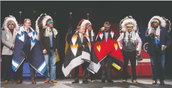  ?? BRANDON HARDER ?? Winnipeg Jets governor Mark Chipman NHL commission­er Gary Bettman and Calgary Flames president-ceo John Bean stand with the gifts of star blankets they were given by First Nations leaders during a luncheon as part of festivitie­s prior to the NHL Heritage Classic being played Saturday at Mosaic Stadium.