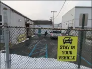  ?? DAN SOKIL - MEDIANEWS GROUP ?? Employee Kane Yuzon of Boardroom Spirits in Lansdale takes an order from a drive-up customer, behind signs telling visitors to stay in their vehicle.