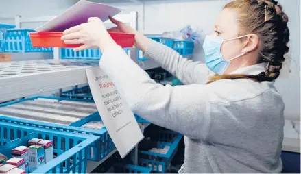  ?? HUGH HASTINGS/GETTY ?? Kimberly Olds, a technician for Britain’s National Health Service, prepares COVID-19 vaccines Wednesday at the Royal Cornwall Hospital in Truro. More than 50 hospitals in the nation have been designated as vaccine hubs.