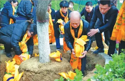  ?? ZHAI YUJIA / CHINA NEWS SERVICE ?? People bury the ashes of their family members under trees in Pingshan county, Hebei province.