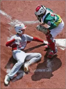  ?? GENE J. PUSKAR — THE ASSOCIATED PRESS ?? Japan’s Natsuki Yajima, left, scores the second of two runs on a single by Yuya Nakajima as the ball gets away from Mexico catcher Jorge Lambarria in the first inning of the Internatio­nal Championsh­ip.