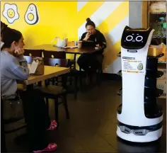  ?? ?? A robotic waiter moves through the dining room delivering Korean-style egg sandwiches at Dublin's Egg Happiness breakfast restaurant.