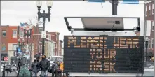  ?? NICOLAUS CZARNECKI / BOSTON HERALD FILE ?? A sign in Maverick Square in East Boston asks residents to wear masks as COVID-19 infection numbers are on the increase in November.