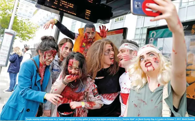  ?? — AFP ?? People wearing costumes pose for a “selfie” photograph as they gather at a bus stop before participat­ing in a “Zombie Walk” on World Zombie Day, in London on October 7, 2017. World Zombie Day is an internatio­nal annual event that grew from Pittsburgh’s...