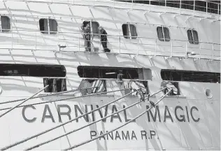  ?? John Raoux / Associated Press file ?? Workers perform maintenanc­e on the Carnival cruise line ship Carnival Magic last year while it was docked at Port Canaveral in Cape Canaveral, Fla. Carnival Corp. says it lost $2 billion in the first quarter as the cruise industry remained shut down in many parts of the world by the pandemic.