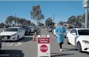  ?? Jae C. Hong, The Associated Press ?? Student nurse Ryan Eachus collects forms as cars line up for COVID- 19 testing at a testing site set up the OC Fairground­s in Costa Mesa, Calif., on Monday.