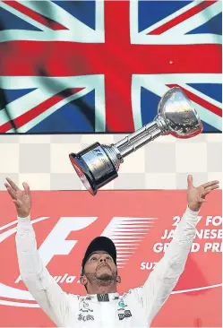  ?? Picture: Getty. ?? Lewis Hamilton celebrates victory in Suzuka to open a 59-point gap on main championsh­ip rival Sebastian Vettel.