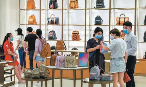  ?? LUO YUNFEI / CHINA NEWS SERVICE ?? Tourists purchase luxury goods at a duty-free store in Haikou, capital of South China’s Hainan province, on May 2.