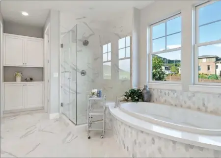  ??  ?? Luxurious master suites feature European-style cabinetry, glass-enclosed showers and 6-foot jetted tubs.