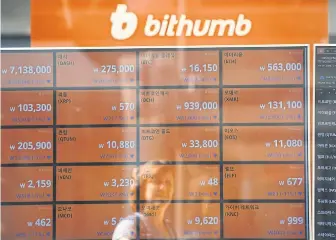  ?? AFP ?? A woman is reflected on a screen showing exchange rates of cryptocurr­encies at Bithumb office in Seoul yesterday.