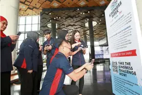 ??  ?? Taking the challenge: SP Setia employees signing up for the #StandToget­her Kindness Challenge at its headquarte­rs in Setia Alam.
