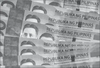  ?? JULIAN ABRAM WAINWRIGHT/ BLOOMBERG ?? The Philippine central bank has cut rates to damp gains in the peso — due to funds being sent home from Filipinos working overseas. Their remittance­s represent about 10 per cent of the economy.