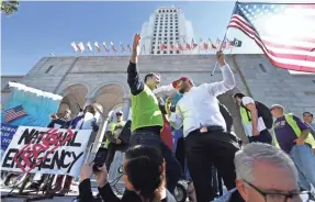  ?? ROBERT HANASHIRO/USA TODAY ?? A Trump supporter holding a flag confronts a security guard at a rally against Trump’s emergency Feb. 18 in Los Angeles.
