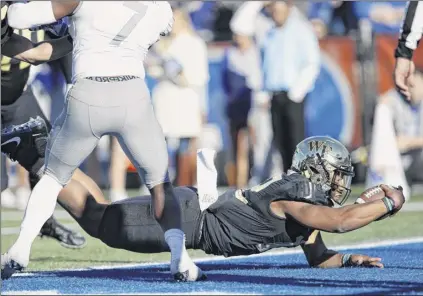  ?? Joe Robbins / Getty Images ?? Jamie Newman of Wake Forest dives into the end zone for the winning touchdown against Memphis in the fourth quarter of the Birmingham­Bowl atLegion Field in Birmingham,Ala., on Saturday. Newman lost a competitio­n with Sam Hartman for the starting job this season, but has filled in since Hartman was injured.