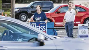  ?? LANNIS WATERS / THE PALM BEACH POST ?? Margie Yansura and Gregg Weiss campaign near the polling place at First Evangelica­l Lutheran Church in West Palm Beach on primary election day Tuesday. Weiss was running for County Commission District 2.