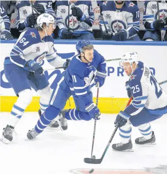  ?? POSTMEDIA NEWS ?? Winnipeg Jets defenceman Logan Stanley (left) checks Maple Leafs forward Zach Hyman during the first period in Toronto on Monday night. Stanley was making his NHL debut.