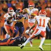  ?? Justin Edmonds Getty Images ?? THE CHIEFS’ Patrick Mahomes looks for a receiver after avoiding a tackle by Denver’s Derek Wolfe.