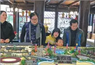  ?? PHOTOS BY YANG JUN / CHINA DAILY ?? Li Baojie (second from left), a beneficiar­y of the Fanhua Sharing Cooperativ­e project, from Baiyun district in Guiyang, learns about the project’s progress with her family in Fanhuali commercial town.