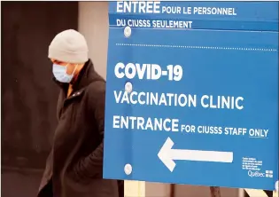  ?? CP PHOTO RYAN REMIORZ ?? A man walks past the COVID-19 vaccinatio­n site at Maimonides LTC facility on Wednesday in Montreal.