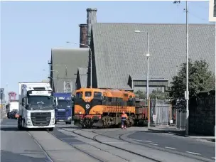  ?? TONY MIROLO ?? Left: Long freight trains running down the street is a scene reminiscen­t of North America or Australia. Any sort of street-running captures the imaginatio­n and makes you want to model it, but since the demise of the Weymouth Tramway or the East Anglian docks, for example, there’s nowhere you can see this any more. While that might be true for Britain, a quick hop across the Irish Sea to Dublin will reveal freight trains and street running is a regular occurrence. Liner trains and ore trains from Tara Mines leave East Wall yard and run down the middle of Alexandra Road towards the docks, being flanked by cars and lorries. With suitable models available from Murphy Models and Irish Railway Models, there’s much potential for a micro layout, or even a room filler!