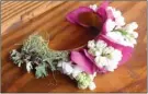  ?? Dean Fosdick via AP ?? Floral designers fashion blooms to fit onto jewelry bases that can be worn around the wrist or finger, used as necklaces, earrings or crowns.