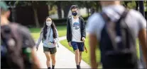  ?? ANDA CHU — STAFF ARCHIVES ?? From left, freshman Reese Maeda, 18, and Tobey Chan, 17, walk along a path at San Jose State University in San Jose on Aug. 19. Students returned to campus Thursday after a long COVID-19shutdown. SJSU will offer 60% of classes in person this semester.